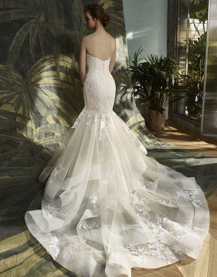 Bride seen from behind in a strapless lace dress with a long tulle train