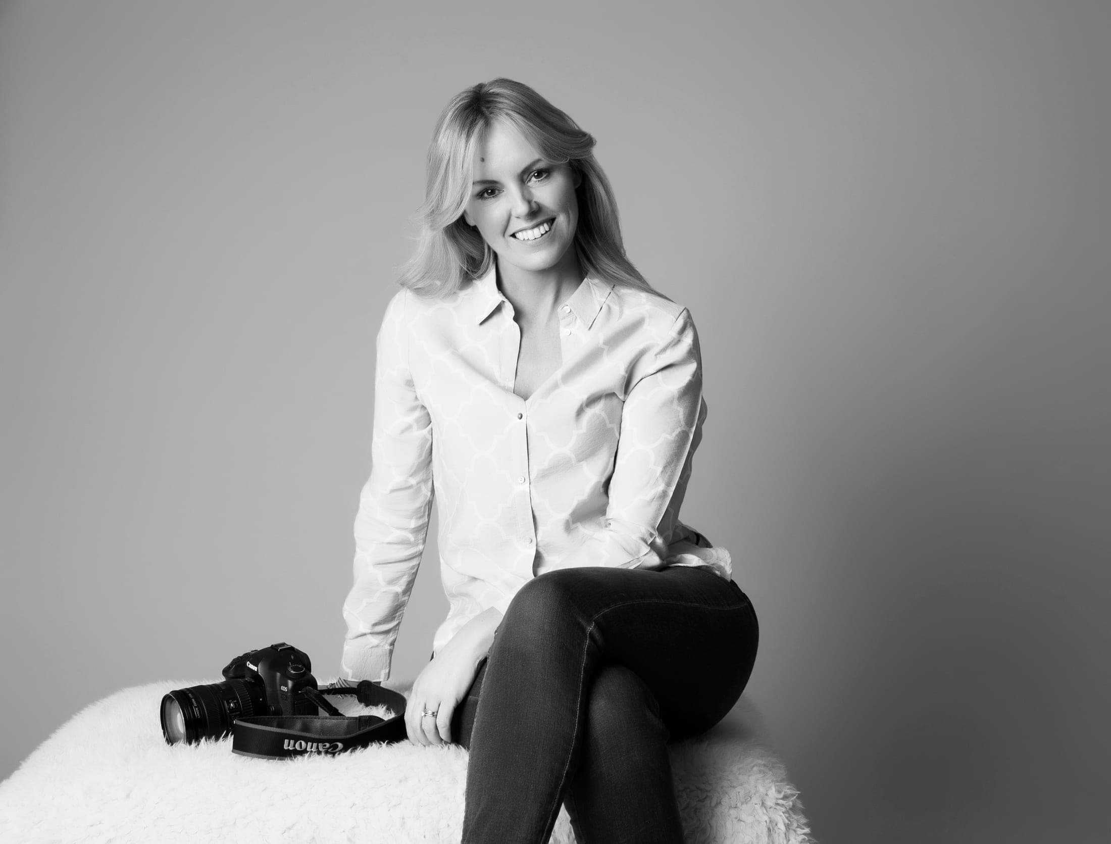Jenny McCarthy sitting beside her camera, in black and white